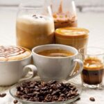 Several cups of coffee with different types of preparations, as well as various coffee beans of the same product