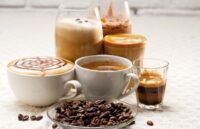 Several cups of coffee with different types of preparations, as well as various coffee beans of the same product