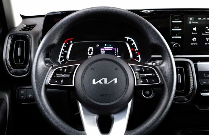 The interior of a Kia car, showing the steering wheel and the main control panel.