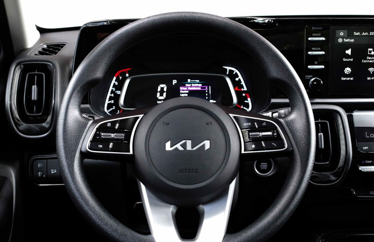 The interior of a Kia car, showing the steering wheel and the main control panel.