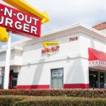 One of the In-N-Out stores with its white facade and its logo in yellow and red colors