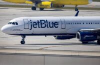 A JetBlue airplane parked at the airport with its iconic white and blue colors