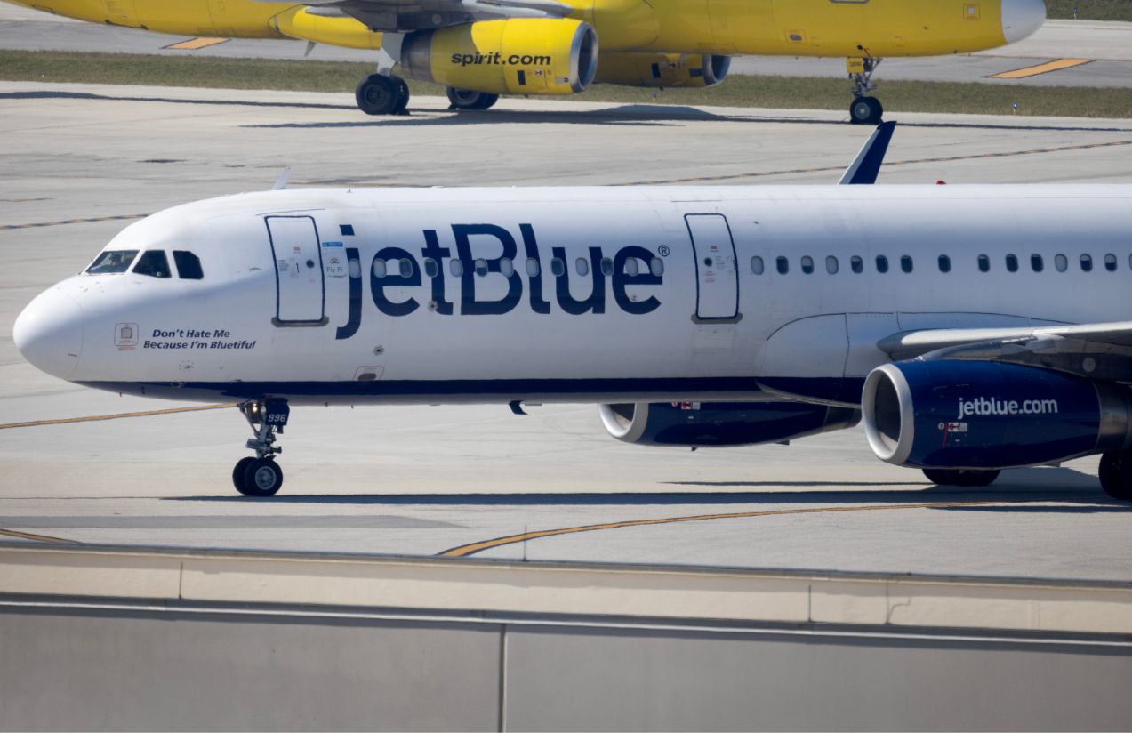 A JetBlue airplane parked at the airport with its iconic white and blue colors