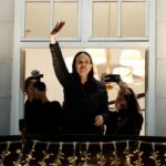 María Corina leaning out from her hotel balcony, greeting all her supporters in Oslo