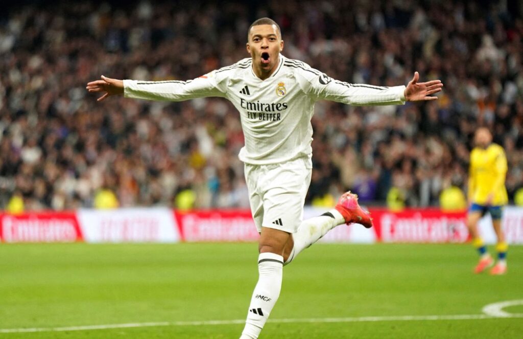 Mbappé celebrating euphorically one of his goals with his arms wide open as he runs toward the stands