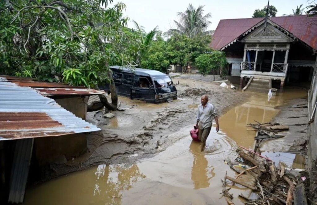 A home completely engulfed by water and mud after the storm that is ravaging Asia