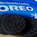 A blue package of Oreo cookies with some of the cookies coming out of the package