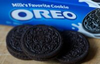 A blue package of Oreo cookies with some of the cookies coming out of the package