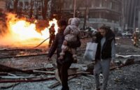 A couple carrying their belongings and their baby amid chaos and destruction after the missile attacks