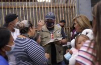 A person conducting surveys with a group of people about asylum in the United States