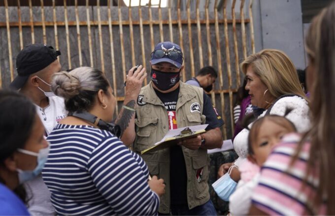 A person conducting surveys with a group of people about asylum in the United States