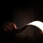 A person holding an OLED light panel with their hands