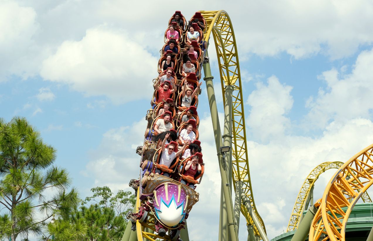 Many people riding a roller coaster, having fun as shown by the expressions on their faces