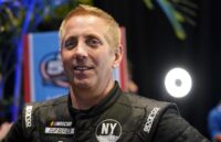 The former NASCAR driver posing for the cameras in his iconic black uniform.