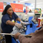 A Walmart employee assisting different customers inside the store