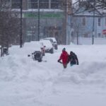 Two people walking through the snowstorm that hit New York