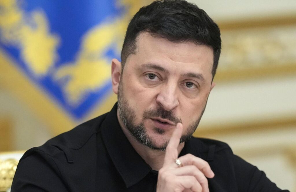 Zelensky seated at a table, addressing everyone present at a meeting