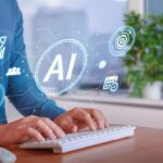 A person working on their computer while several AI symbols and icons appear on the screen