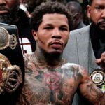 The American boxer raising a championship belt with a very serious expression