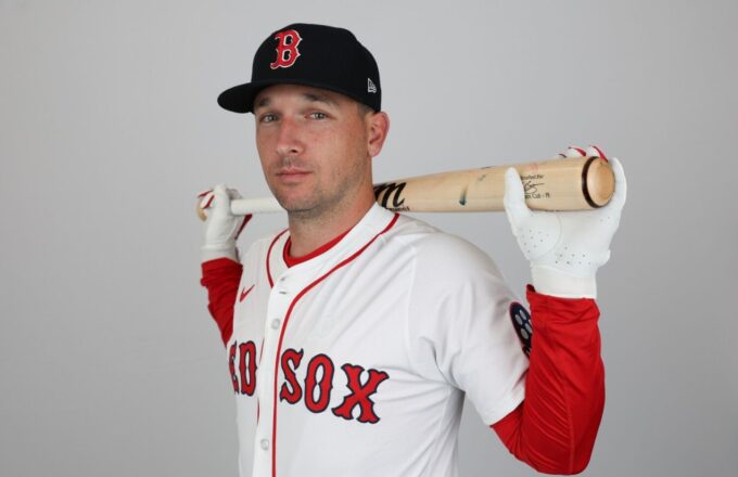 The experienced player holding his bat behind his neck with both hands