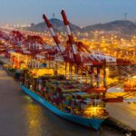 The majestic and well-known port of China loading cargo onto a ship with one of its cranes