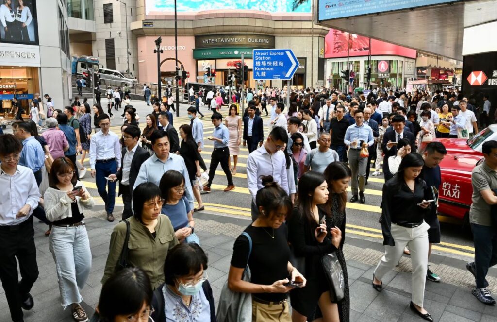 A street in China crowded with many people walking to their jobs