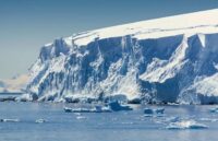 A panoramic photo of a massive ice glacier that looks like a white wall