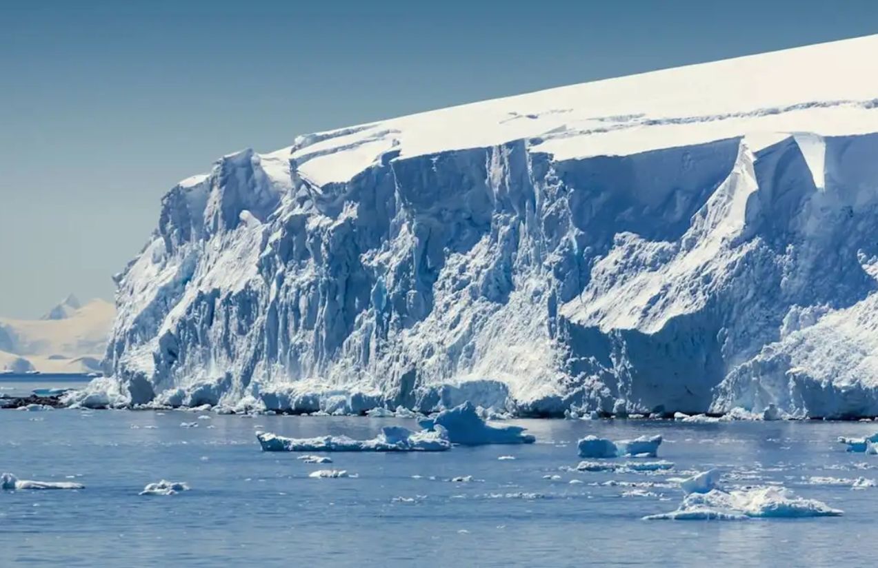 A panoramic photo of a massive ice glacier that looks like a white wall