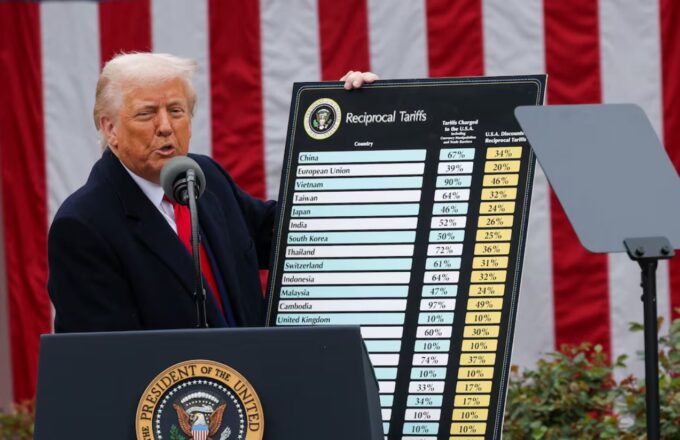 Donald Trump holding a chart showing the tariffs he imposed on different countries