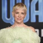 The renowned Hollywood actress posing for the cameras on the red carpet at one of Marvel’s movies, wearing a beautiful dress and a striking blonde look