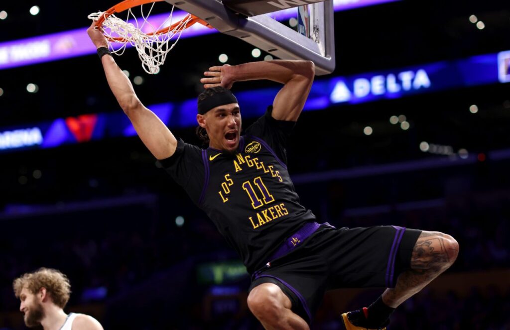 The young Lakers player hanging from the basketball rim in a flashy way