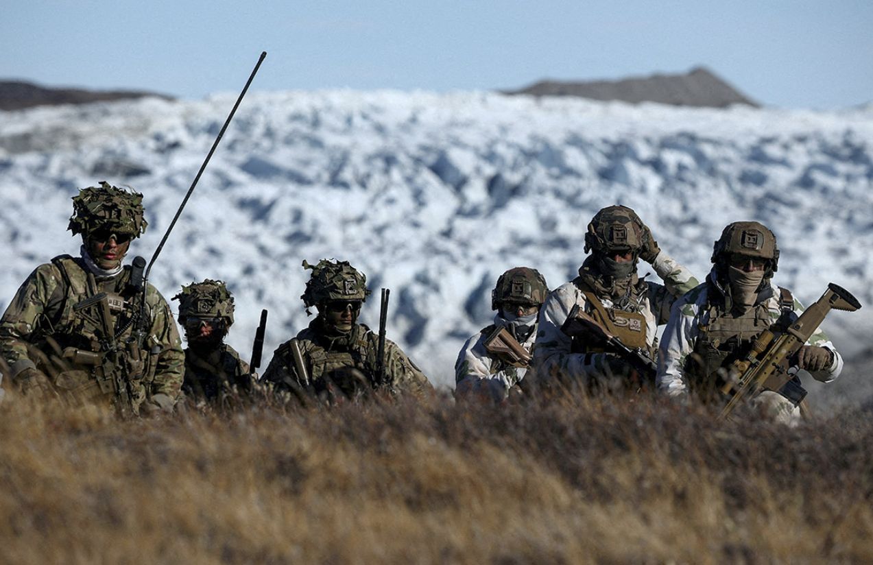 Several German military personnel walking through the cold mountains of Greenland during one of their patrols