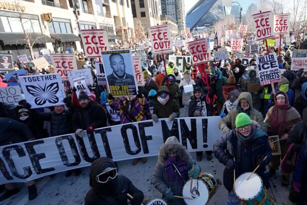 Many people in the United States protesting against ICE, holding signs that read “ICE Out.”