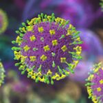 An image showing several purple viruses with green spikes