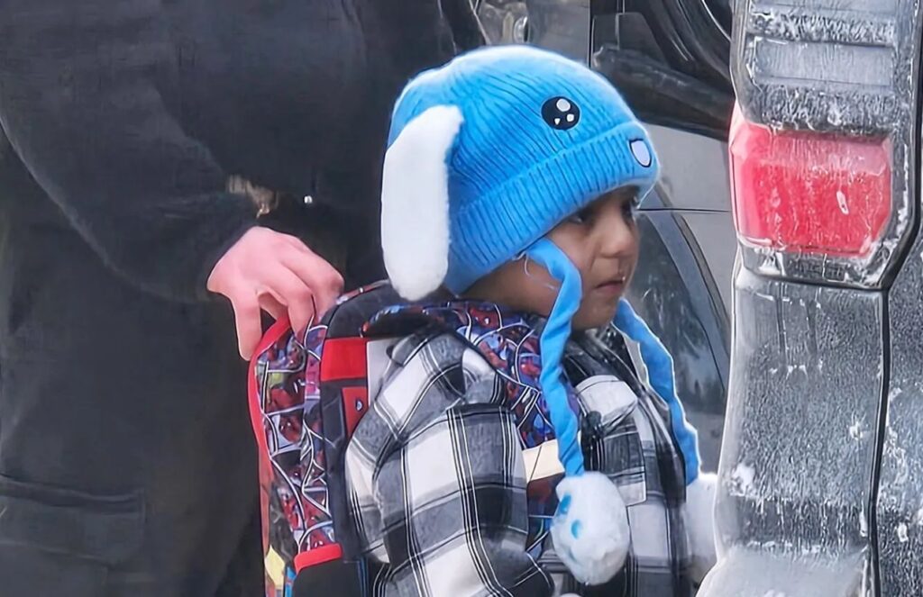 Little Liam being held by an officer while he is detained for deportation