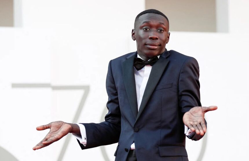 The famous influencer on an important red carpet making his well-known gesture in front of the cameras