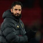 The former Manchester United head coach standing on the pitch, looking toward the horizon