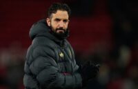 The former Manchester United head coach standing on the pitch, looking toward the horizon
