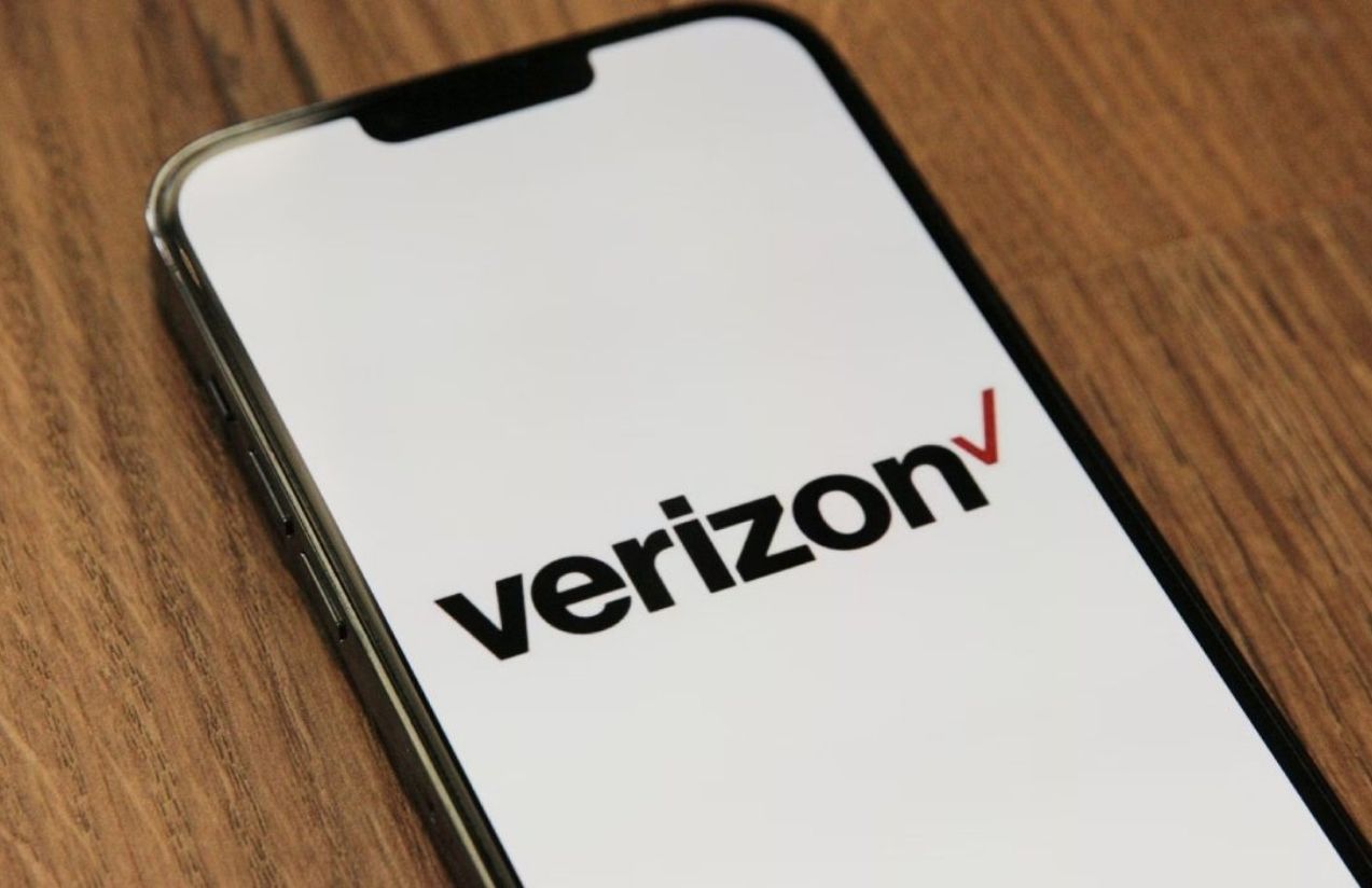 A cell phone displaying the Verizon logo and the word “Verizon” on its screen