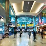 Miami suspends flights to the Caribbean after the capture of Nicolás Maduro An interior view of Miami International Airport, with many lights and several people looking for their flights