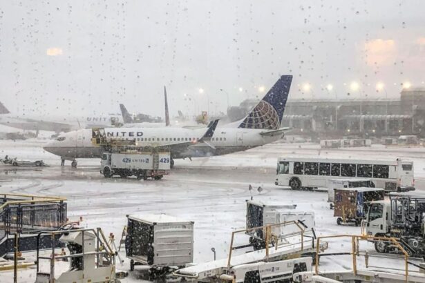 An airplane covered in snow and surrounded by several security vehicles