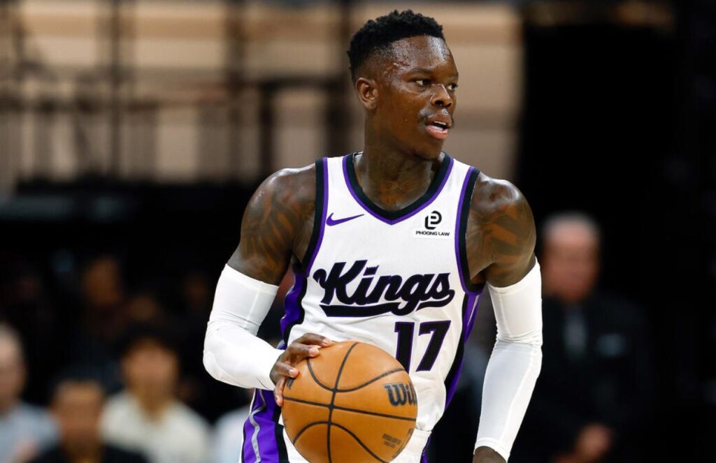The German player holding the ball while dribbling past players from the opposing team