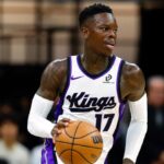 The German player holding the ball while dribbling past players from the opposing team