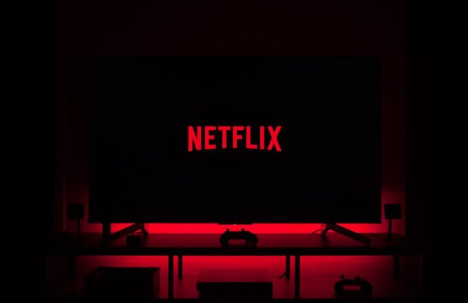 A room in complete darkness, with only a television surrounded by red lights and the word “Netflix” in the center