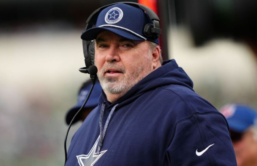 Mike wearing Cowboys coach attire, giving instructions through his headset