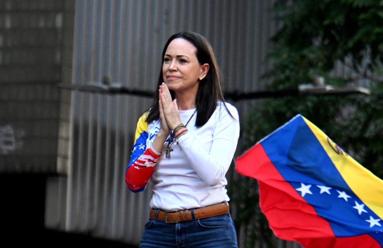 María Corina with a very happy expression, her hands clasped together as a sign of gratitude to her supporters