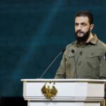 The leader of the Kurdish militias speaking at a conference in front of several people
