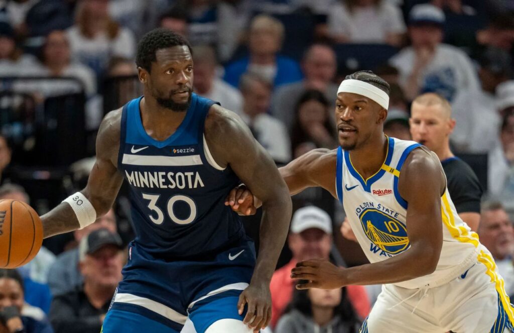 Julius Randle protecting the ball while Jimmy Butler tries to defend him and keep him away from the basket