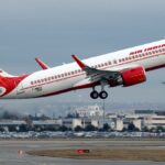 A large white and red airplane taking off from an airport