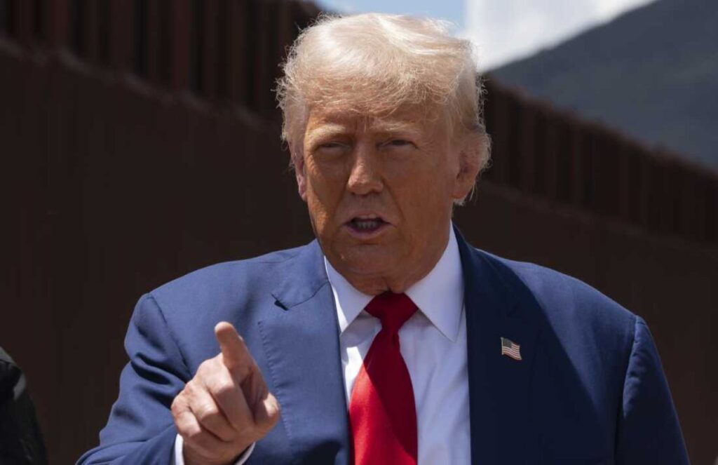 Donald Trump in his iconic elegant suit pointing his finger at a crowd